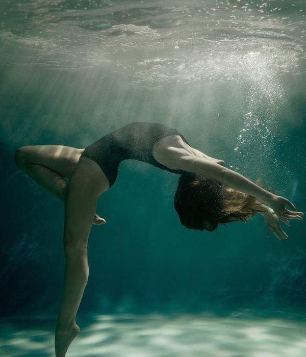 Woman in a dynamic dance-like yoga pose, expressing fluidity and grace.
